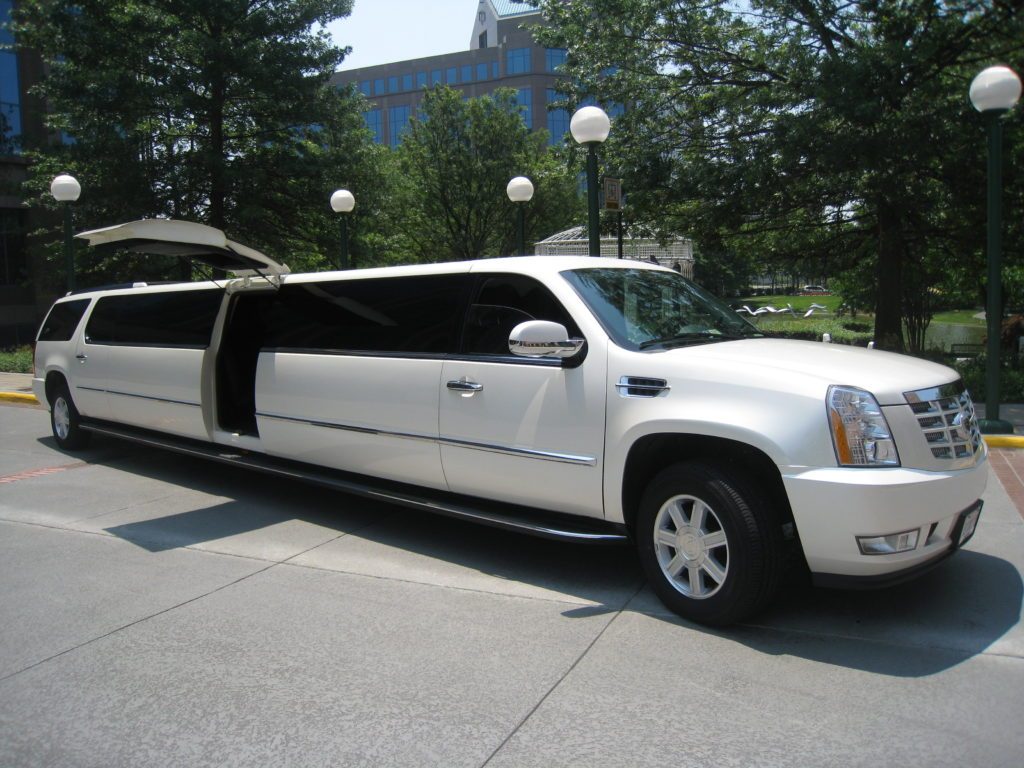 A white limo is parked in the parking lot.