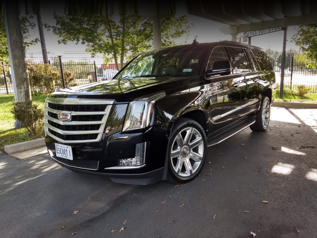 A black suv parked in the driveway of a house.