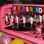 A pink oven with candles and happy birthday sign.