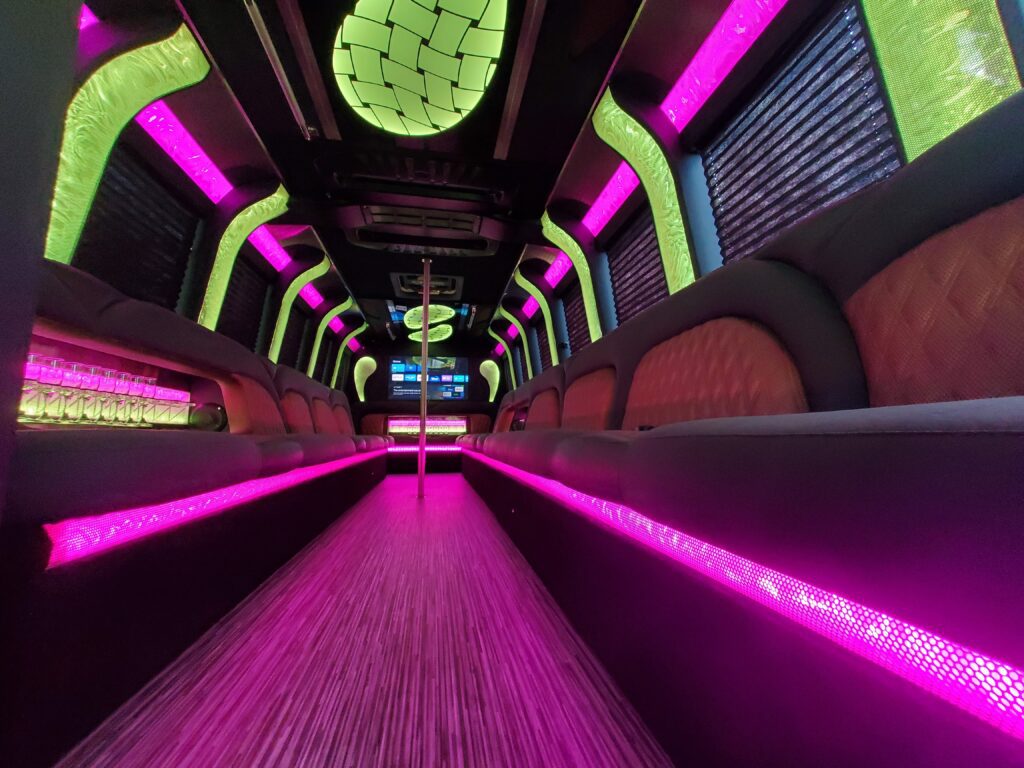 Luxury party bus interior with vibrant lighting.