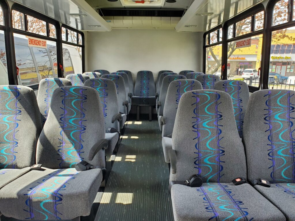 Empty bus interior with patterned seats.