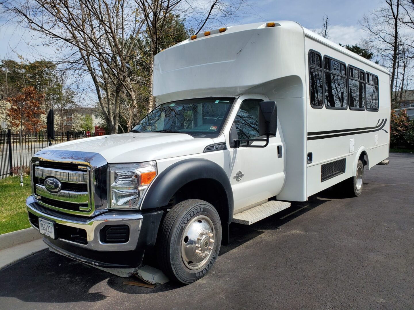 White passenger bus parked on asphalt road.