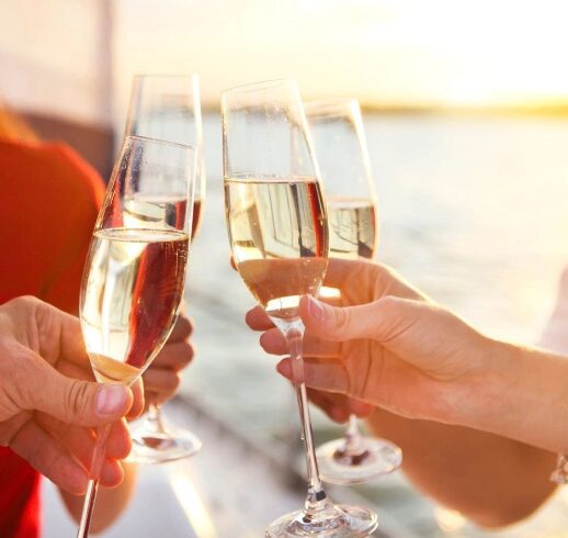 Toasting with champagne glasses near the water.